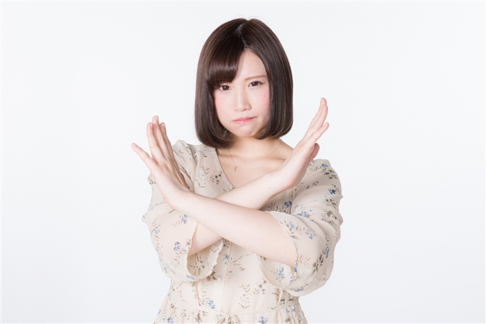 バツをする女性の画像