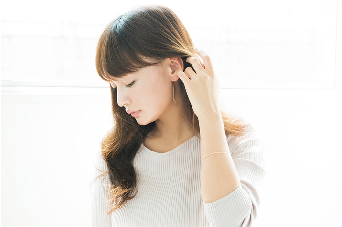 髪をなでる女性の画像